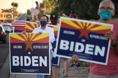 Members of the group "Arizona Republicans Who Believe In Treating Others With Respect" hold signs in support of Democratic presidential candidate Joe Biden, during evening rush hour in Phoenix, Arizona on October 16, 2020. AFP