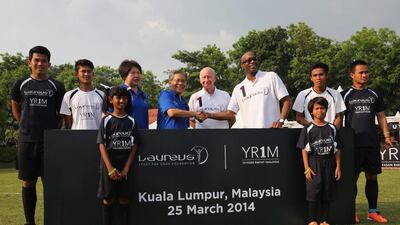 Su Ling, CEO of YR1M, Tan Sri Dato Lodin bin Wok Kamaruddin, Laureus Academy Member Sir Bobby Charlton and Laureus Chairman Edwin Moses pose for an LSFG/YR1M announcement during the Laureus All Stars Unity Cup on Tuesday. Ian Walton / Getty Images / March 25, 2014