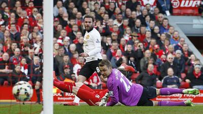 Juan Mata beats Liverpool keeper Simon Mignolet for Manchester United's first goal in their eventual 2-1 Premier League victory at Anfield on Sunday. Phil Noble / Reuters