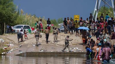 A state trooper addresses a group of migrants, many from Haiti, who are crossing into Del Rio, Texas, from Mexico on Saturday, AFP