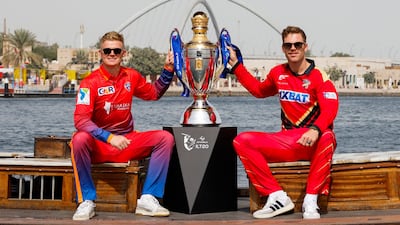 Sam Billings, the captain of Dubai Capitals, left, and Lockie Ferguson, of Desert Vipers, pose with ILT20 trophy on an abra at Dubai Creek. Courtesy ILT20