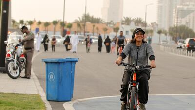 Eman Joharjy, a fashion designer in one of her own creations, cycles along Jeddah's Corniche. Reuters