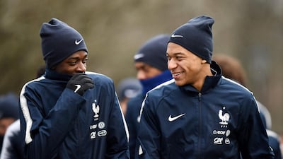 French forwards Ousmane Dembele, left, jokes with Kylian Mbappe before a training session in Clairefontaine-en-Yvelines, southwest of Paris. Franck Fife / AFP