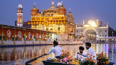 Sikh devotees transport flowers on a boat as they decorate the Golden Temple on the eve of the anniversary of the first installation of the Sikh holy book Guru Granth Sahib in Amritsar. AFP