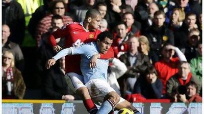Carlos Tevez struggles to fend off the challenge of Chris Smalling, who put in a commanding performance for United.