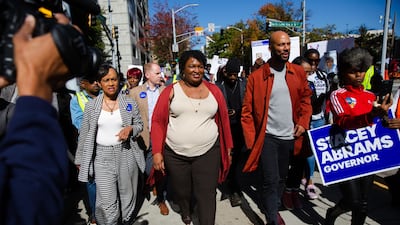 Ms Abrams and rapper Common lead a 'Souls to the Polls' march in Atlanta. Bloomberg