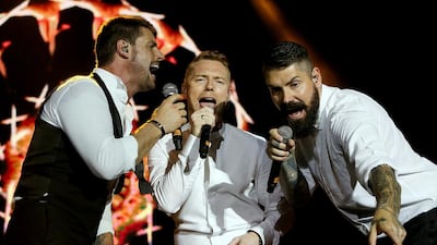 From left, Keith Duffy, Ronan Keating and Shane Lynch were the trio from Boyzone who took to the stage at the Dubai Tennis Stadium. Satish Kumar / The National