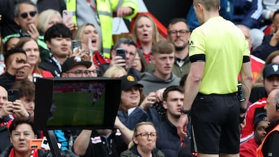 Referee Michael Salisbury looks at the pitch-side monitor to check for a handball before deciding to allow Matheus Cunha's goal for United. AFP