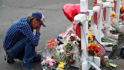 Antonio Basco cries beside a cross at a makeshift memorial near the scene of a mass shooting at a shopping complex, in El Paso, Texas. AP Photo/John Locher