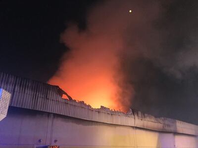 Smoke rises over one of the two warehouses that caught fire on Tuesday night in Al Quoz. Courtesy Dubai Civil Defence