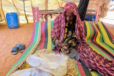 A displaced Sudanese woman prepares food at a shelter in Al Rahmaniya camp, near El Obeid in the Kordofan region. AFP