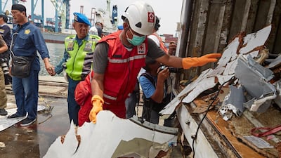Search and rescue workers carry wreckage to a lorry.