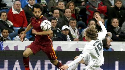 Real Madrid midfielder Luka Modric, right, fights for the ball with Roma winger Mohamed Salah. Kiko Huesca / EPA