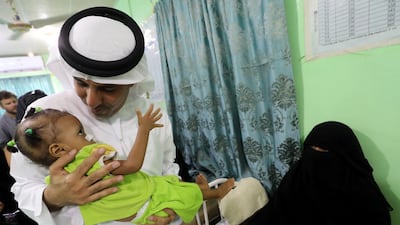 The UAE's Humanitarian Operations Director for Yemen, Saeed Al Kaabi carrying a Yemeni child diagnosed with malnutrition at a hospital in Mukalla. AFP