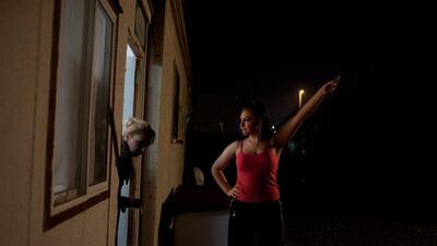 Sylvia Cramerova, 18, aka Yayahoop, a hula hoop artist, reaches out her cell phone hoping to get a better reception as she stands outside of her family's backstage trailer.