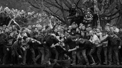 Oliver Scarff won 1st prize of the 'Sports - Singles' category for this image which shows members of opposing teams, the Up'ards and Down'ards, grapple for the ball during the historic, annual Royal Shrovetide Football Match in Ashbourne, Derbyshire. EPA/OLIVER SCARFF/AFP