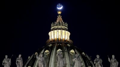 The moon moves behind St Peter's Basilica before the recitation of the Holy Rosary for Pope Francis' health at the Vatican. AP