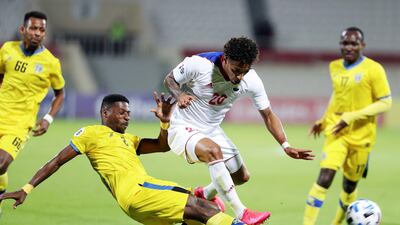 Ryan Mendes of Sharjah is tackled by Yassin Barnawi of Al Taawoun. Chris Whiteoak / The National