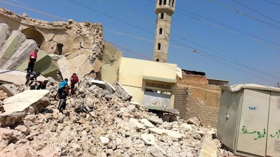 Iraqi boys stand over the rubble of the grave of a Sufi cleric in Mosul. Members of ISIL have demolished dozens of Sufi sites. EPA