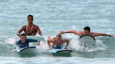 Scott Chambers, MD of Surf Dubai, teaching students how to surf at Jumeirah beach in Dubai. The company's operations have since been halted over a dispute with the municipality over appropriate permits. Pawan Singh / The National