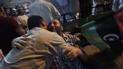 Libyans embrace each other as tens of thousands of Libyans celebrate the arrest of Kadhafi's son Saif al-islam and the partial fall of Tripoli in the hands of the Libyan rebels on August 21, 2011 in Benghazi, Libya. Libyan rebels have reached the highly s???