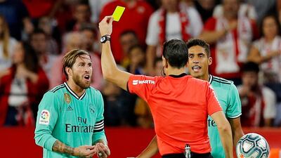 Real Madrid's Sergio Ramos is shown a yellow card by referee Juan Martinez Munuera. Reuters