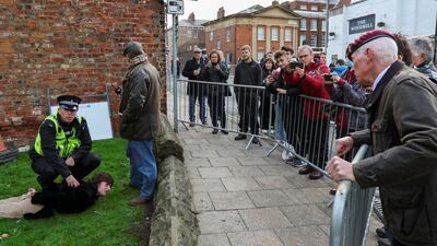 Police restrain a man who threw an egg at Britain's King Charles III during his visit to York. Reuters
