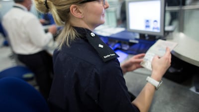 Border Force officers check the passports of passengers arriving at Gatwick Airport in 2014, in London, England. Getty Images
