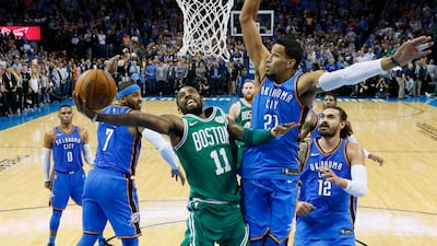 Boston Celtics guard Kyrie Irving shoots between Oklahoma City Thunder forward Carmelo Anthony and guard Andre Roberson in the second quarter of an NBA basketball game in Oklahoma City. Sue Ogrocki / AP Photo