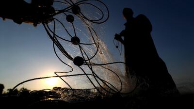 A fisherman holds a fishing net on the waters of the Pharaonic Sea in Monufia, Egypt. AFP