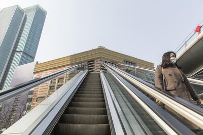 A pedestrian rides an escalator in the Lujiazui Financial District of Shanghai, China, on Monday. Many workers have been told by companies to stay at home after the Lunar New Year holiday ended due to the worsening coronavirus outbreak. Bloomberg