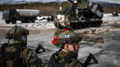Soldiers from the Finnish Defence Forces stand in front of a M270 Multiple Launch Rocket System. AFP