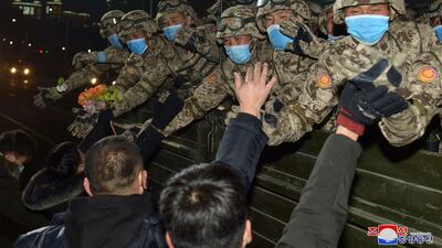 North Korean soldiers greet people during a military parade. KCNA / AFP