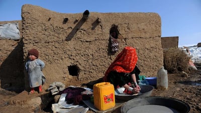 An Afghan internally displaced woman washes clothes on February 10, 2014, at Sakhi camp in Mazar-i-Sharif. Taliban fighting in southern Afghanistan forced many families to flee their homes and spend the harsh winter season at the camp in poverty. Farshad Usyan / AFP photo