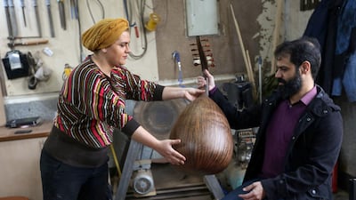 Iranian luthier Fatemeh Moussavi gives an oud to musical artist and instructor Hamid Khansari at her workshop in Tehran. AFP