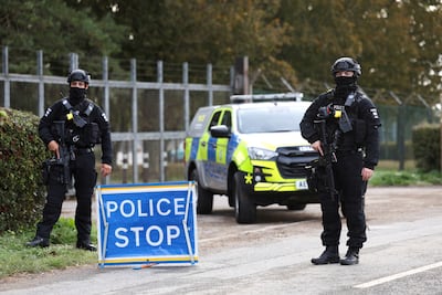 Armed police officers stand guard on a road outside the perimeter of the RAF Fairford airbase after a security incident. Reuters