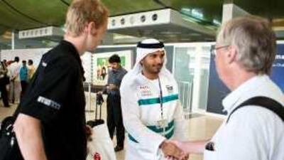 Mohammed al Zaabi, a volunteer supervisor for Takatof, greets visitors as they arrive at the Abu Dhabi airport yesterday.