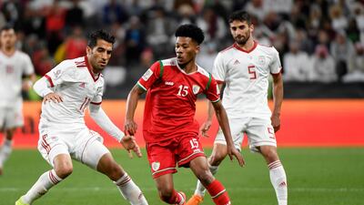 Oman forward Jameel Al Yahmadi, centre, is marked by Iran midfielder Vahid Amiri, left, during their Asian Cup last-16 match in Abu Dhabi on Sunday. Khaled Desouki / AFP