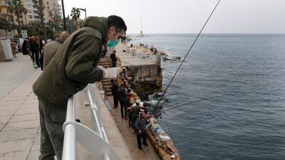 A municipal policeman, orders fishermen to leave the corniche, or waterfront promenade, along the Mediterranean Sea in Beirut. AP Photo