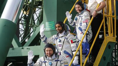 The astronauts give a final wave as they ascend the steps of the Soyuz. Maxim Shipenkov / AFP