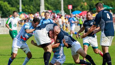 Gulf Legends (dark blue) take on Airbus (light blue stripes) during Day 1 of the Dubai Rugby Sevens on Thursday. Victor Besa for The National