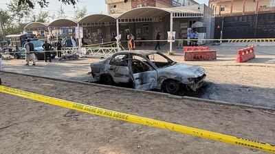 Security officials examine damaged vehicles. AP