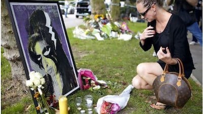 A women pays her respects in front of a painting of Amy Winehouse outside her house in North London yesterday, the day after the singer was found dead. Kerim Otken / EPA
