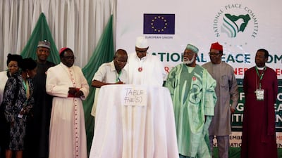 Nigeria's President Muhammadu Buhari stands next to APC national Chairman Adams Oshiomole during a signature of a commitment to good behaviour in the February 2019 elections. Reuters