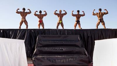 Bodybuilders flex their muscles during a bodybuilding competition at the Dubai public beach.