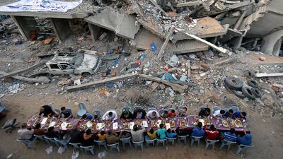 Palestinians break their fast by eating the Iftar meals during the holy month of Ramadan, near the rubble of a building recently destroyed by Israeli air strikes, in Gaza City May 18, 2019. REUTERS