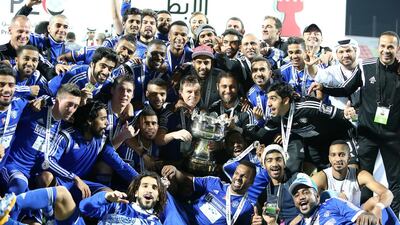 Al Nasr players and staff celebrate with the Arabian Gulf Cup trophy after their victory over Sharjah. Pawan Singh / The National