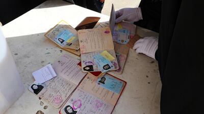 An election officer checks the identification documents of Iranian voters at a polling station in the capital Tehran during the country's presidential election. AFP
