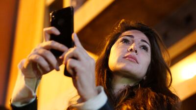 Dima Sadek films an anti-government protest in Beirut in 2019. One of her tweets has caused a backlash among supporters of Hezbollah and the Amal Movement. AP