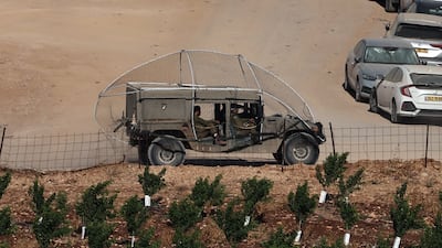 An Israeli military vehicle covered in an anti-drone screen drives along the Israel-Lebanon border. EPA
